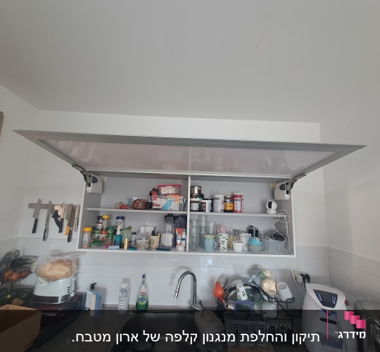 ארון מטבח פתוח עם כלים ומוצרי מזון